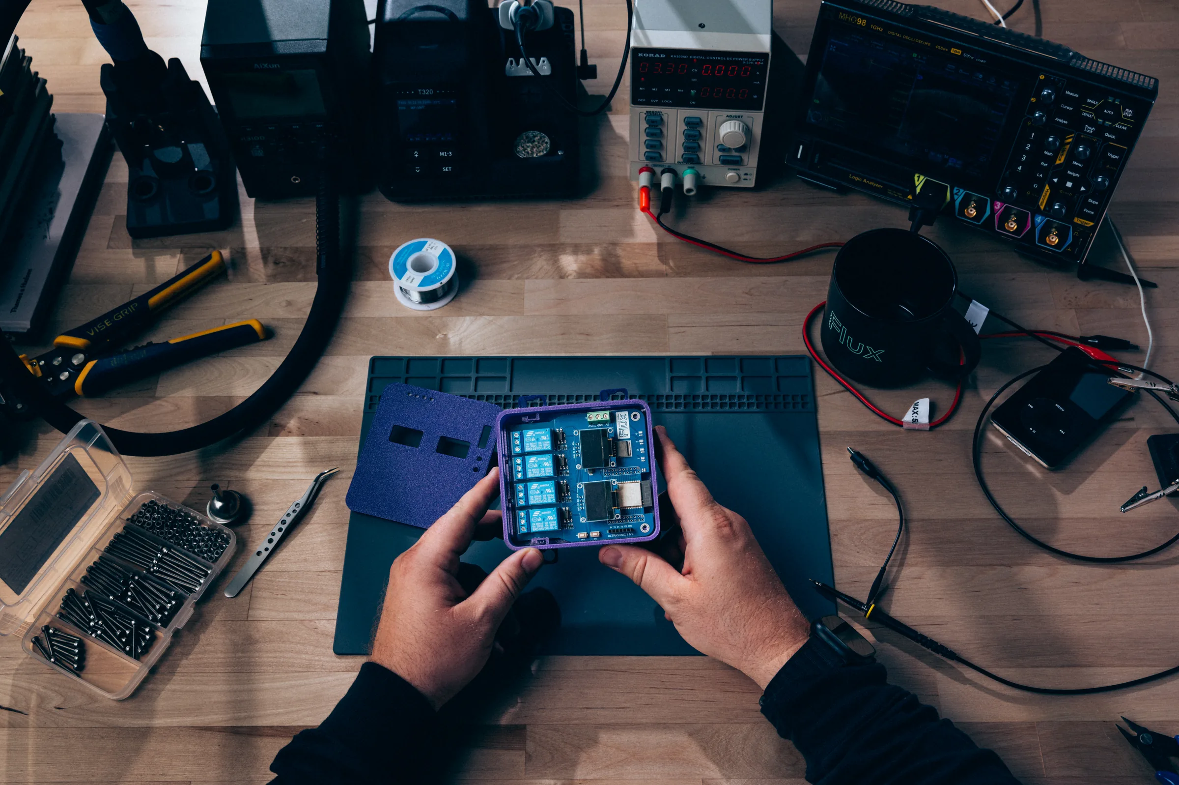 An engineer holds a relay board in a blue 3D-printed enclosure