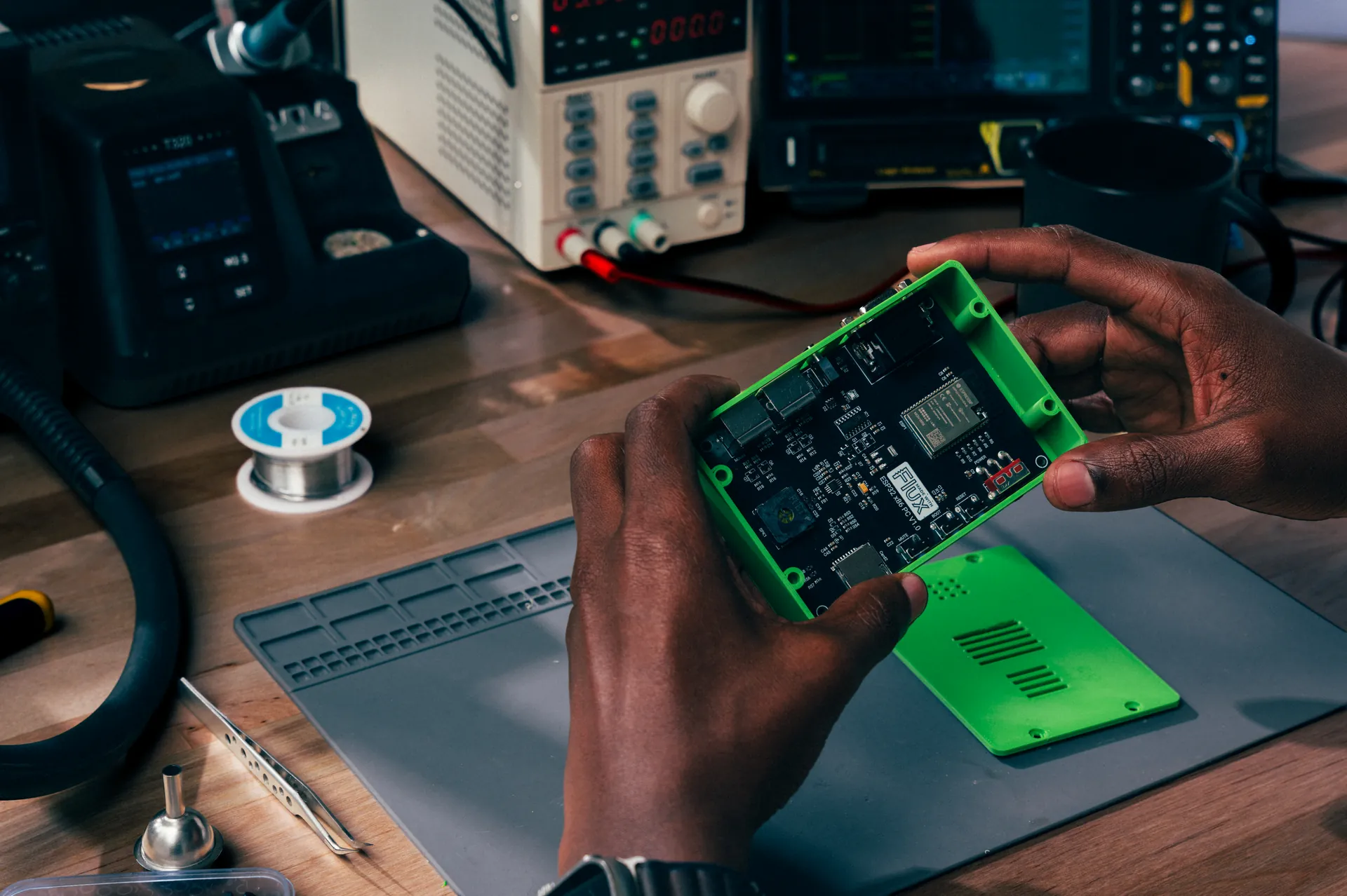 Hands holding an assembled board in its enclosure.